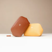 Brown and yellow hexagonal pouches on a beige background