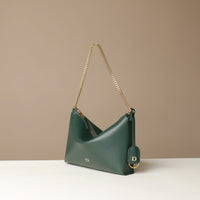 Green Danilos handbag with gold chain strap on a beige background