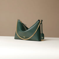 Green Danilos handbag with gold chain detail on a beige background