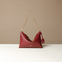 Red Danilos handbag with a gold chain strap on a beige background