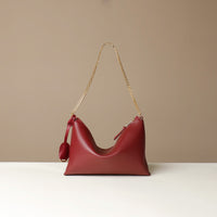 Red Danilos handbag with a gold chain strap on a beige background