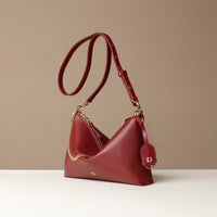 Red Danilos handbag with gold chain detail on a beige background
