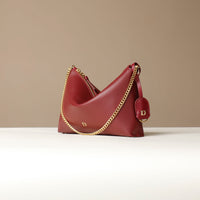 Red Danilos handbag with gold chain strap on a beige background
