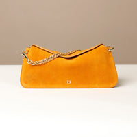 small Yellow suede leather danilos  handbag with a gold chain on a beige background
