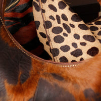 Close-up of a leopard print Danilos bag with a brown leather bag.