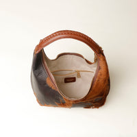 upper view Brown hair on danilos  leather handbag with zipper inside on a white background