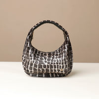 Black and white hair on leather patterned danilos  handbag on a beige background