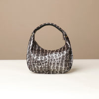 black and grey danilos hair on leather Handbag with a textured pattern on a beige background