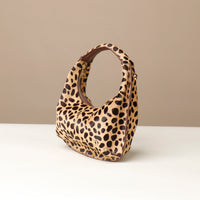 hair on leather Leopard print danilos  handbag on a beige background
