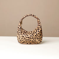 hair on leather Leopard print danilos  handbag on a beige background