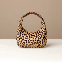 hair on leather Leopard print danilos  handbag on a beige background