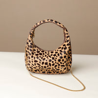 hair on leather Leopard print danilos  handbag with a chain detail on a beige background