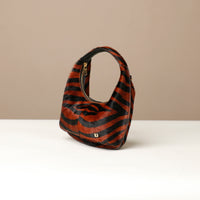 Zebra-striped hair on leather danilos handbag on a beige background