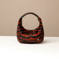 Zebra-striped hair on leather danilos handbag on a beige background