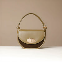 Front View of Green Danilos handbag with gold accents on a beige background