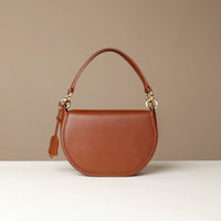 Brown Danilos leather handbag on a beige background
