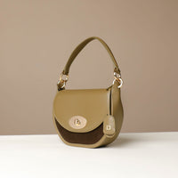 Green Danilos handbag with gold accents on a beige background