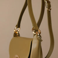 green Danilos handbag with gold hardware on a beige background