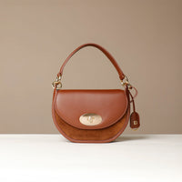 Brown handbag with gold accents on a beige background