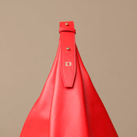 Red handbag with a strap on a beige background