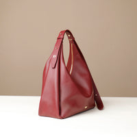 Red leather handbag on a beige background