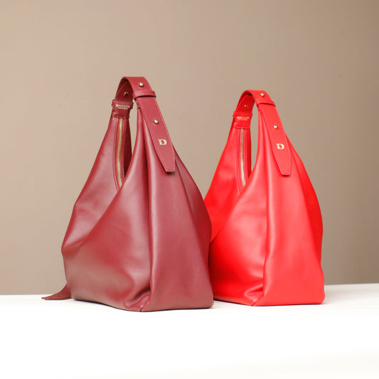 Two red handbags on a beige background