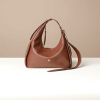 Front view of a brown leather Mini Mia Minimale Danilos handbag with a strap on a beige background