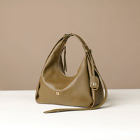 side view of a olive green leather Mini Mia Minimale Danilos handbag with a strap on a beige background