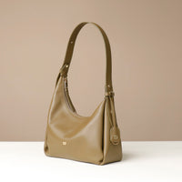 side view of a olive green leather Mini Mia Minimale Danilos handbag with a handle strap on a beige background