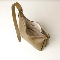 upper view of an open olive green leather Mini Mia Minimale Danilos handbag with a strap on a beige background