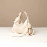 side view of a white green leather Mini Mia Minimale Danilos handbag with a strap on a beige background