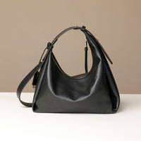 back view of a Black leather Mini Mia Minimale Danilos handbag with a strap on a beige background