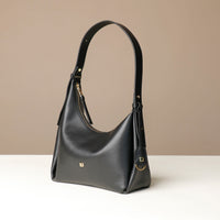 Front view of a Black leather Mini Mia Minimale Danilos handbag with a strap handle on a beige background