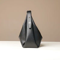 side view of a Black leather Mini Mia Minimale Danilos handbag with the logo on the strap on a beige background