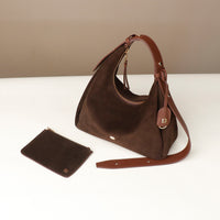 Brown handbag with matching pouch on a white surface