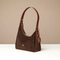 Brown leather handbag on a beige background