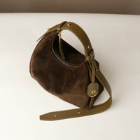 Brown handbag with a strap on a white background