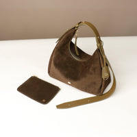 Brown handbag with matching pouch on a white surface