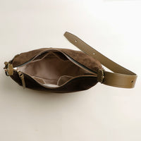 Brown suede waist bag with a strap on a light beige background