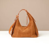 Brown suede handbag on a beige background