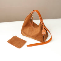 Brown suede handbag with matching pouch on a white surface