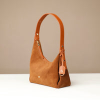 Brown handbag with a strap on a beige background