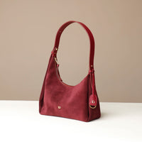 red suede leather danilos handbag on a beige background