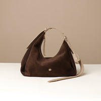 Brown handbag with beige strap on a beige background