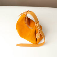 Yellow handbag with a strap on a white background