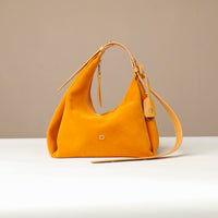 Yellow handbag on a white surface with a beige background