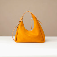 Yellow handbag on a white surface with a beige background