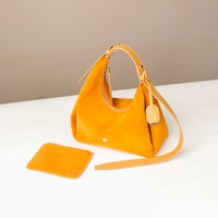 Yellow handbag with matching pouch on a white surface