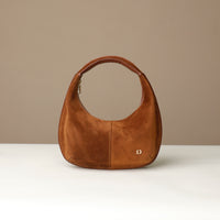 Brown round suede leather danilos handbag on a beige background
