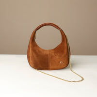 Brown round suede leather danilos handbag with a gold chain on a beige background